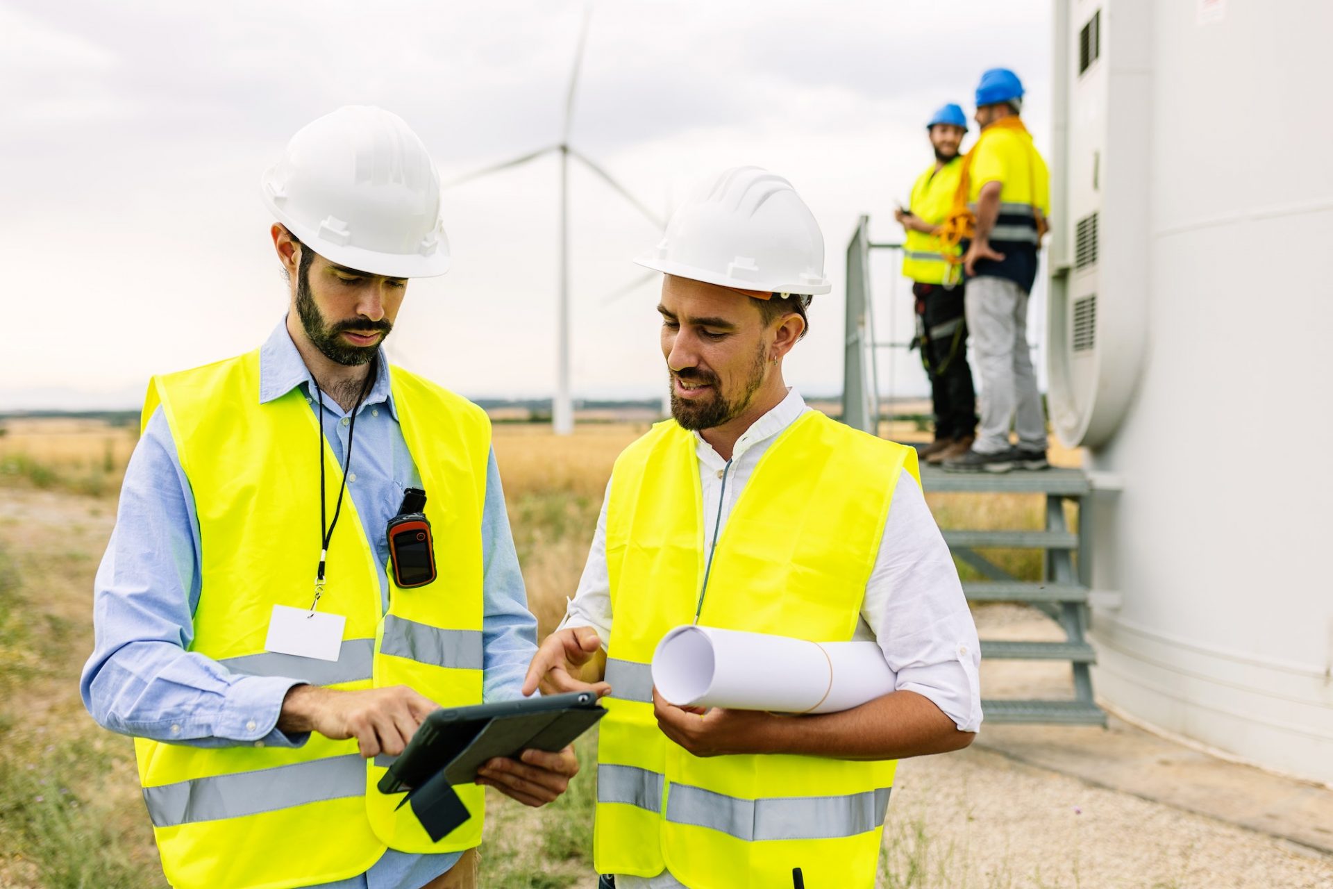 Two young maintenance engineers team working in wind turbine farm